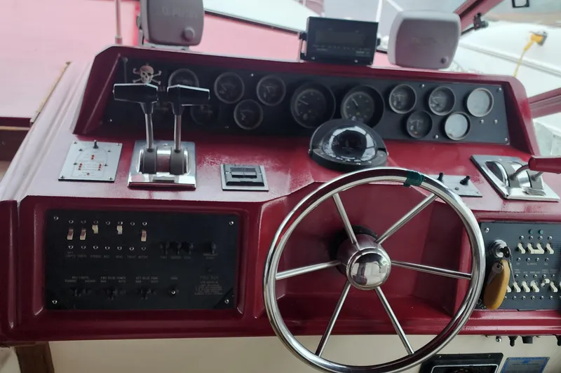 Slide: The Image of 1987 Sea Ray 340 Sundancer helm with red dashboard, steering wheel, and control gauges. - 3