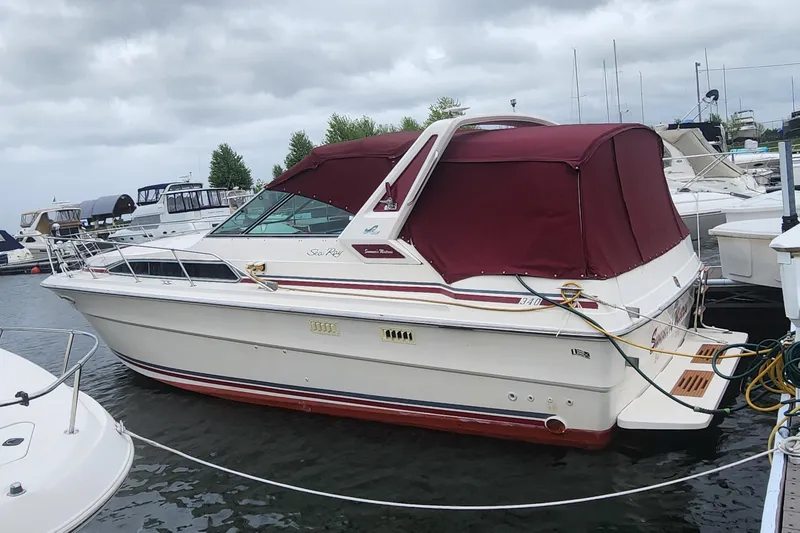Slide: The Image of 1987 Sea Ray 340 Sundancer boat with maroon canopy docked in marina. - 35