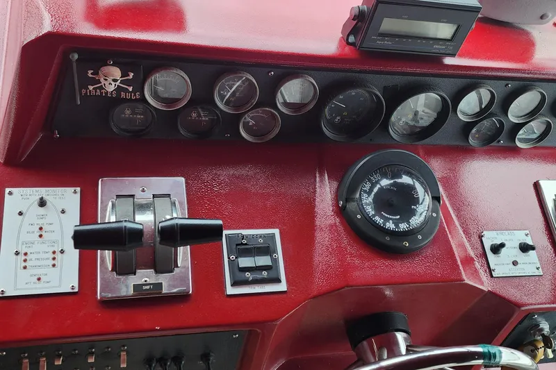 Slide: The Image of 1987 Sea Ray 340 Sundancer dashboard with gauges, controls, and "Pirates Rule" sign. - 4