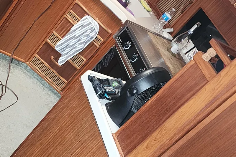 Slide: The Image of Interior of 1987 Sea Ray 340 Sundancer with wooden cabinetry and kitchen appliances. - 8