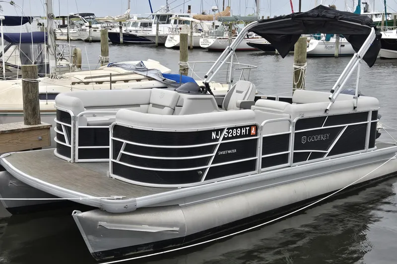 The Image of 2023 Godfrey Sweetwater 2086 CX pontoon boat docked in a marina. - 0