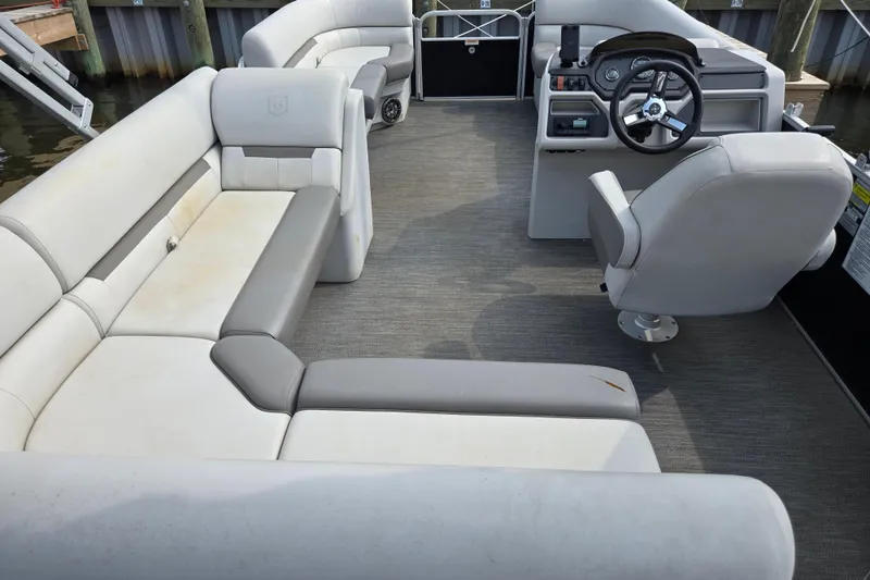 Slide: The Image of Interior of 2023 Godfrey Sweetwater 2086 CX pontoon boat with plush seating and steering console. - 2