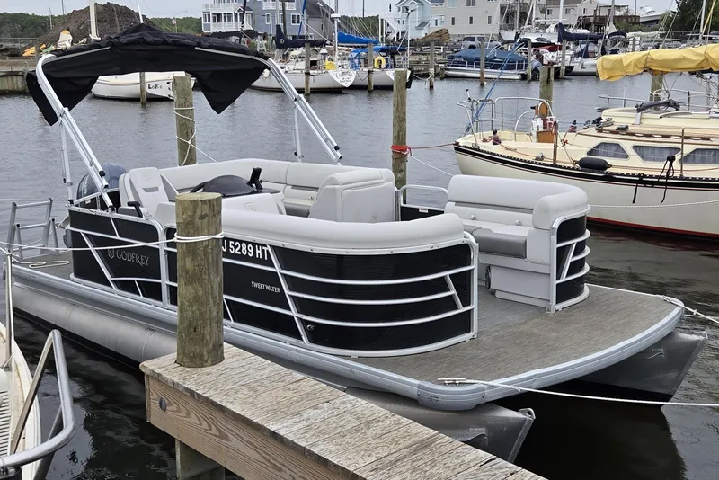 Slide: The Image of 2023 Godfrey Sweetwater 2086 CX pontoon boat docked in a marina. - 7