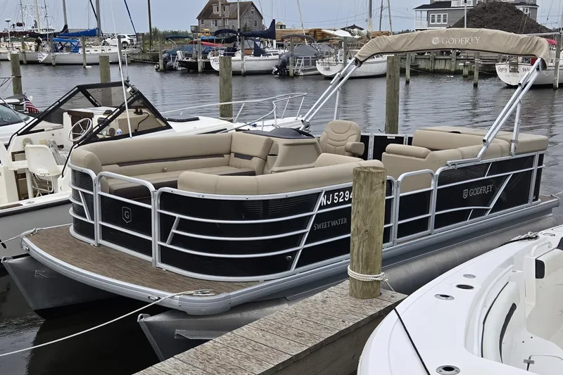 Slide: The Image of 2023 Godfrey Sweetwater 2186 C pontoon boat docked in a marina. - 3