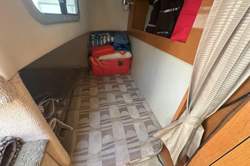 Slide: The Image of 2007 Chaparral Signature 250 cabin interior with bed, storage, and window. - 17