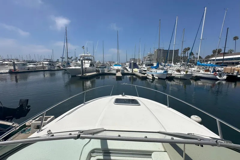Slide: The Image of 2007 Chaparral Signature 250 boat docked in a marina with sailboats and clear sky. - 7