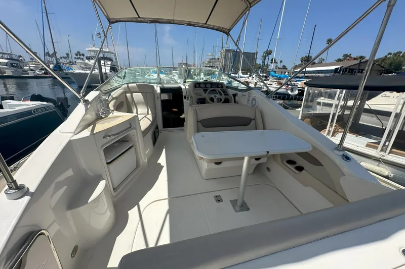 Slide: The Image of 2007 Chaparral Signature 250 boat interior with seating and table, docked in a marina. - 9