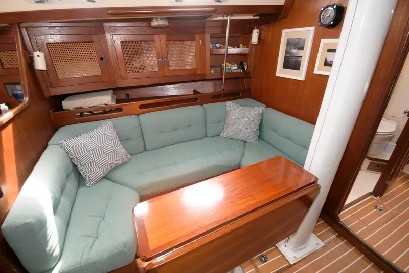 Slide: The Image of Interior of 1985 Tartan 40 sailboat with green cushioned seating and wooden table. - 17