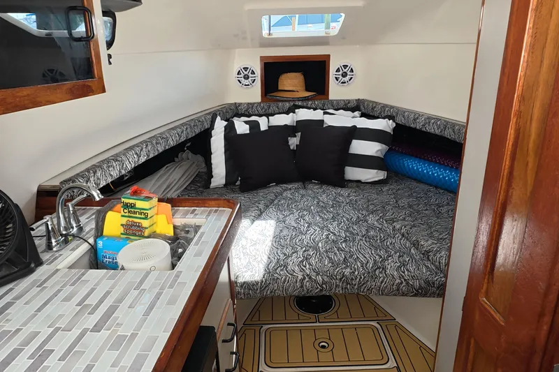 Slide: The Image of 1992 Luhrs 300 Tournament cabin interior with bed, pillows, and kitchenette. - 7