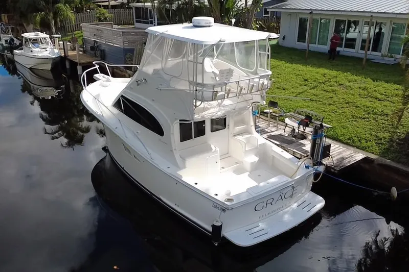 Slide: The Image of 2008 Luhrs 35 Convertible yacht docked by a grassy waterfront property. - 1