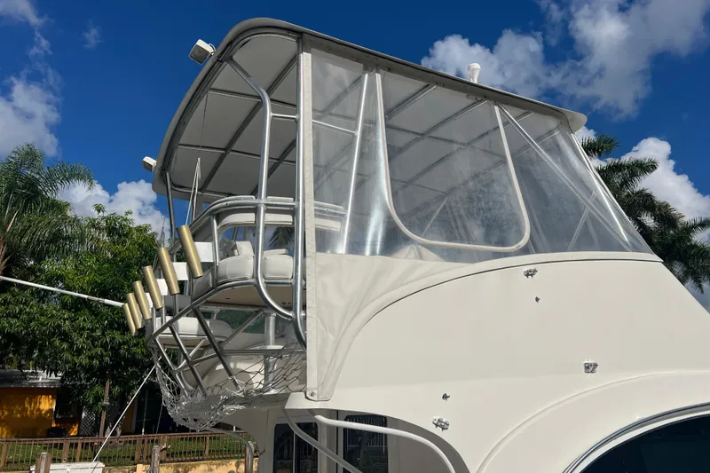 Slide: The Image of 2008 Luhrs 35 Convertible boat with flybridge against blue sky and palm trees. - 11