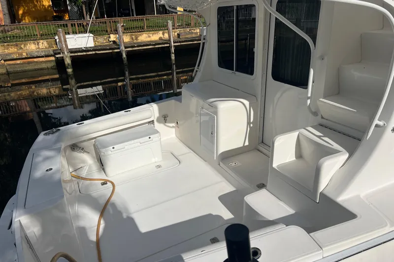Slide: The Image of 2008 Luhrs 35 Convertible boat deck with seating and storage, docked by a canal. - 12