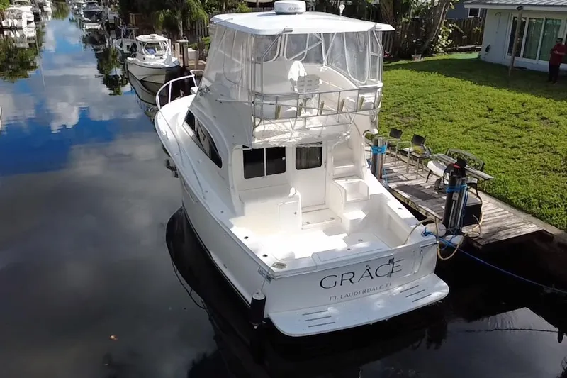 Slide: The Image of 2008 Luhrs 35 Convertible yacht docked in a serene canal setting. - 2