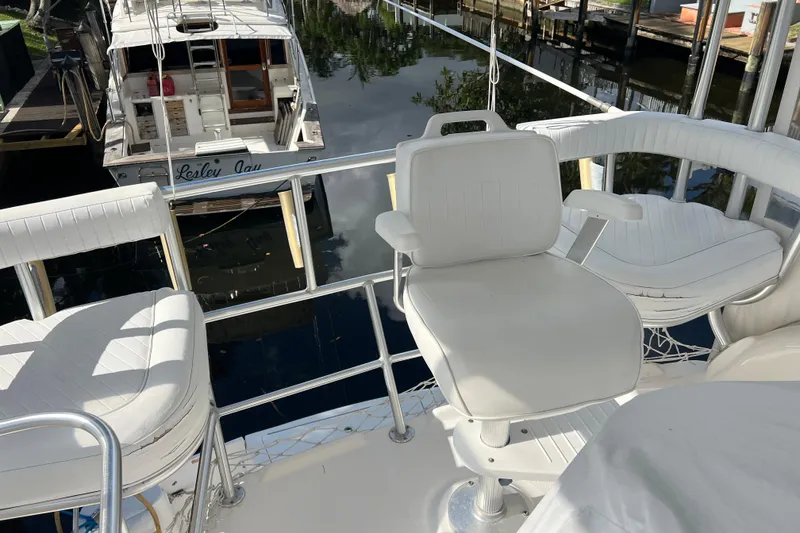 Slide: The Image of 2008 Luhrs 35 Convertible yacht with white seating on deck, docked near another boat. - 28