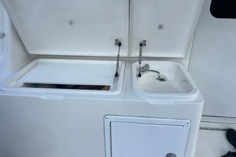 Slide: The Image of 2008 Luhrs 35 Convertible boat sink and storage area with open lids. - 30