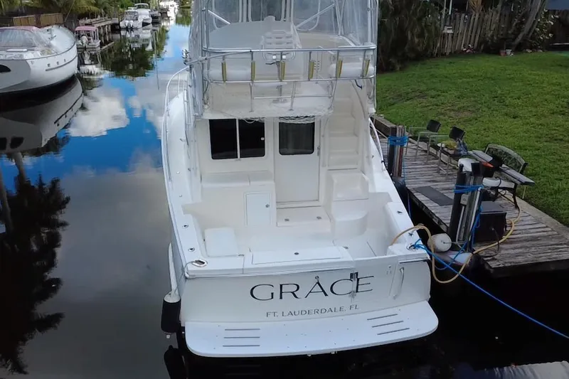 Slide: The Image of 2008 Luhrs 35 Convertible yacht docked in a serene canal setting. - 5