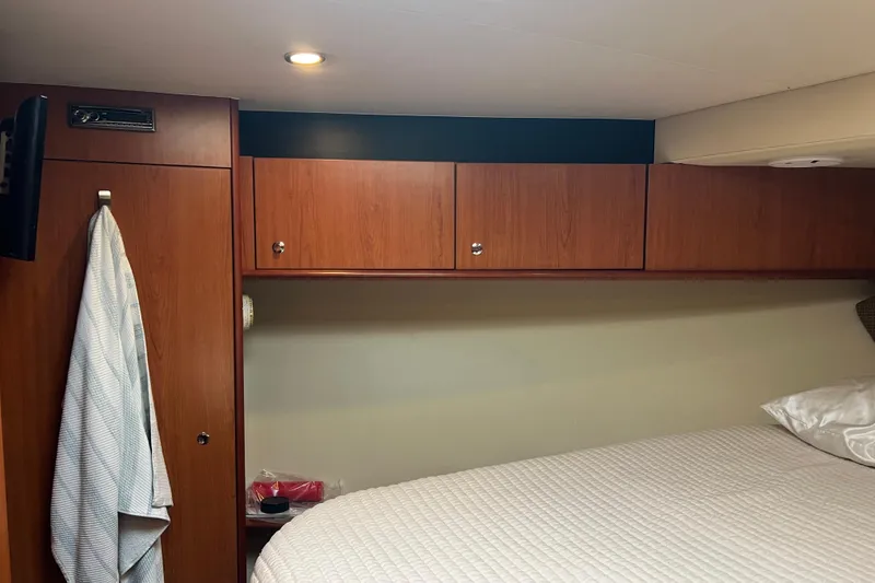 Slide: The Image of 2008 Luhrs 35 Convertible cabin interior with wood cabinets and bed. - 57