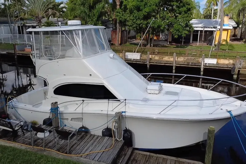 Slide: The Image of 2008 Luhrs 35 Convertible boat docked by a lush, tropical canal. - 7