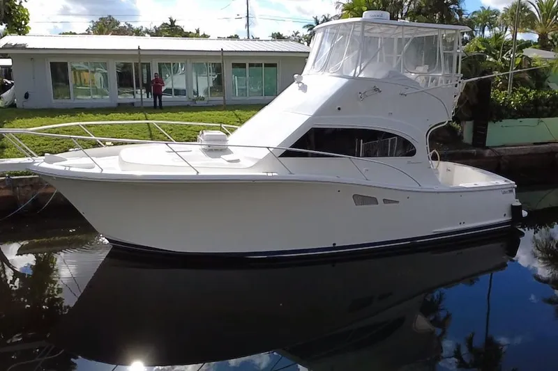 Slide: The Image of 2008 Luhrs 35 Convertible yacht docked by a waterfront property. - 9