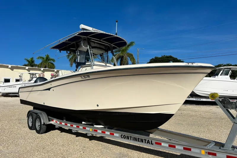 Slide: The Image of 2005 Grady-White Release 283 boat on trailer, parked outdoors under clear blue sky. - 1