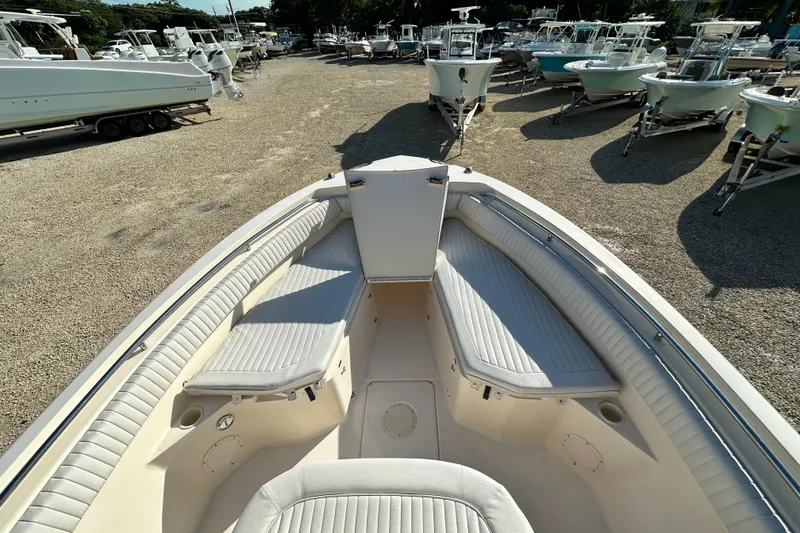 Slide: The Image of 2005 Grady-White Release 283 boat interior with cushioned seating, parked among other boats. - 13