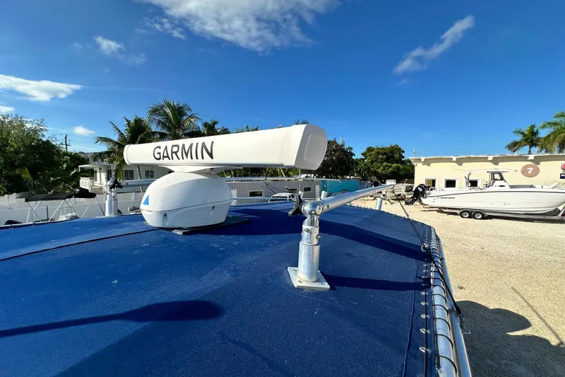 Slide: The Image of 2005 Grady-White Release 283 boat with Garmin radar, parked outdoors under clear blue sky. - 15