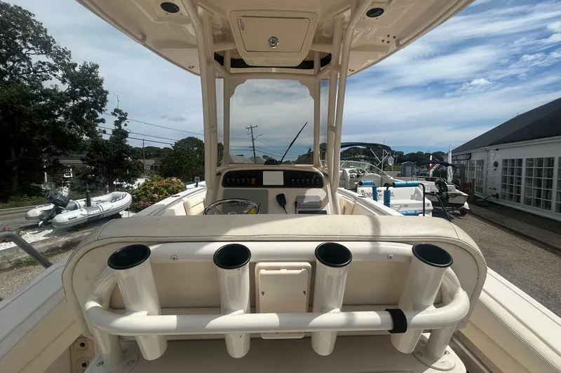 Slide: The Image of 2023 Grady White Fisherman boat interior with rod holders and console, docked outdoors. - 8