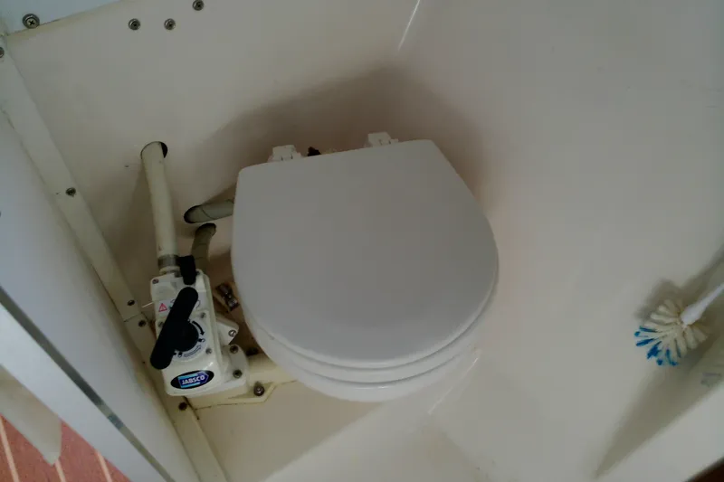 Slide: The Image of Boat toilet in 2000 Atlas Boat Works Acadia 25, featuring manual pump and brush. - 11