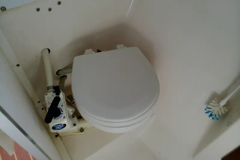 Slide: The Image of Boat toilet in 2000 Atlas Boat Works Acadia 25, featuring manual pump and brush. - 23