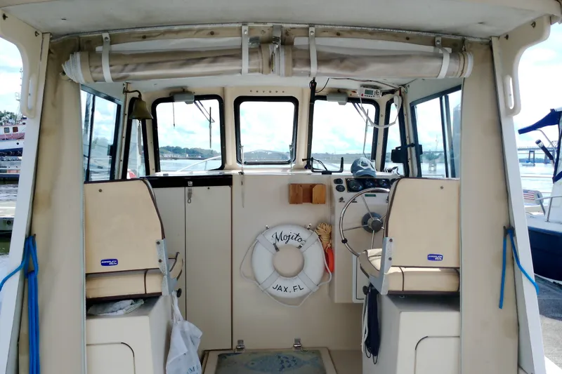 Slide: The Image of Interior view of 2000 Atlas Boat Works Acadia 25, featuring helm and seating area. - 8