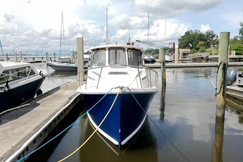 Slide: The Image of 2000 Atlas Boat Works Acadia 25 docked at a marina under cloudy skies. - 3