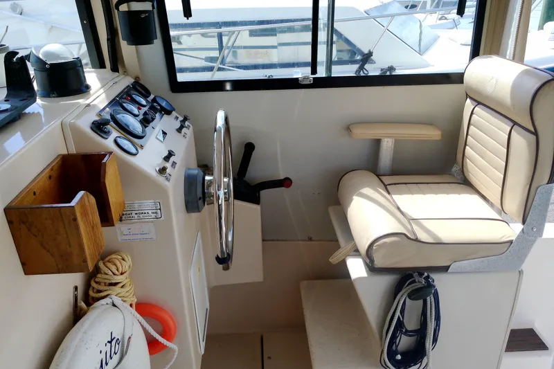 Slide: The Image of Interior helm of 2000 Atlas Boat Works Acadia 25, featuring steering wheel and gauges. - 30