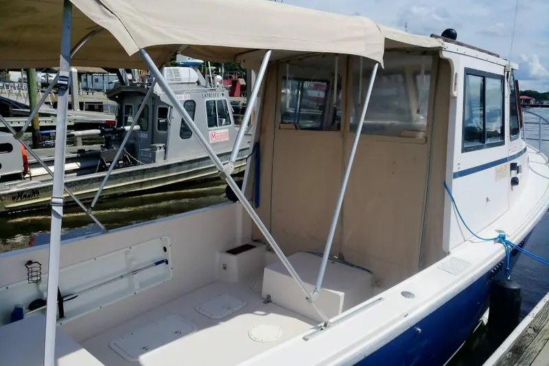 Slide: The Image of Atlas Boat Works Acadia 25, 2000 model, docked with canopy and enclosed cabin. - 33