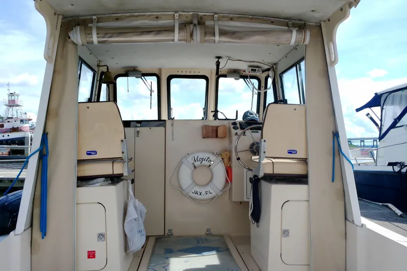 Slide: The Image of Interior view of a 2000 Atlas Boat Works Acadia 25, featuring helm and seating area. - 34