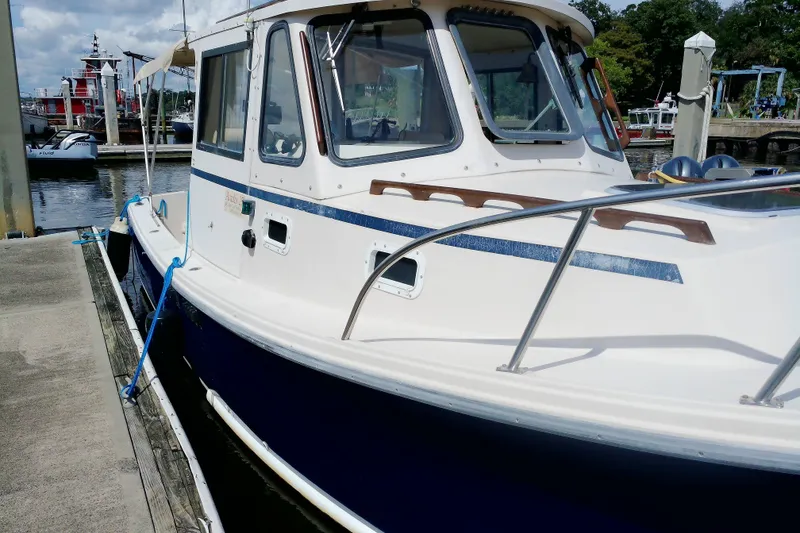Slide: The Image of 2000 Atlas Boat Works Acadia 25 docked at marina, featuring classic design and blue hull. - 5