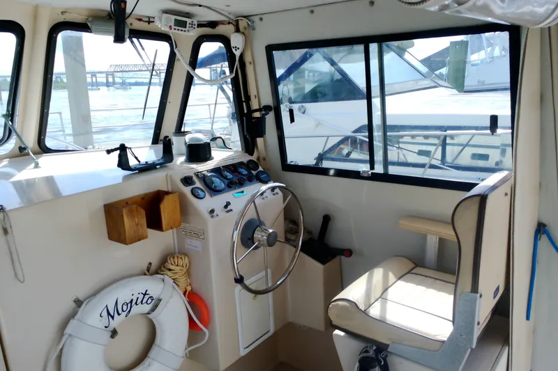 Slide: The Image of Interior of 2000 Atlas Boat Works Acadia 25, featuring helm and navigational equipment. - 9