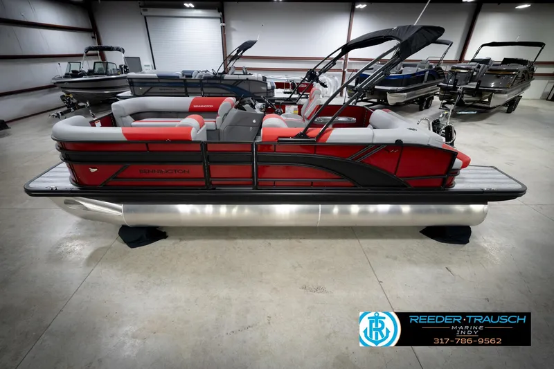 Slide: The Image of 2026 Bennington 22 SLJ pontoon boat in showroom, featuring sleek red and gray design. - 1