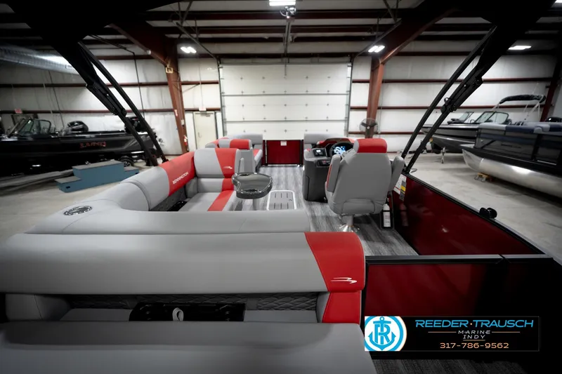 Slide: The Image of 2026 Bennington 22 SLJ pontoon boat interior with red and gray seating in a showroom. - 18