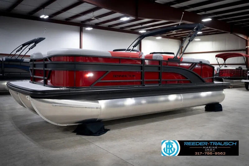 Slide: The Image of 2026 Bennington 22 SLJ pontoon boat in showroom, featuring sleek red design and modern amenities. - 2