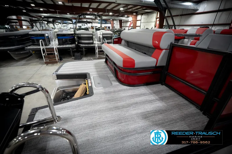 Slide: The Image of 2026 Bennington 22 SLJ pontoon boat interior with red and gray seating in showroom. - 55