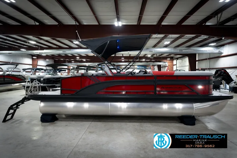 Slide: The Image of 2026 Bennington 22 SLJ pontoon boat in showroom, featuring sleek red and black design. - 6