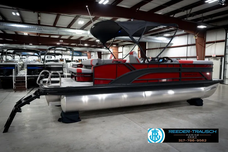 Slide: The Image of 2026 Bennington 22 SLJ pontoon boat in showroom, featuring sleek red and gray design. - 7