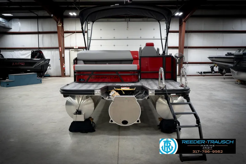 Slide: The Image of 2026 Bennington 22 SLJ pontoon boat in showroom, rear view with ladder and seating. - 8