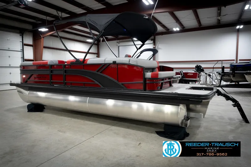 Slide: The Image of 2026 Bennington 22 SLJ pontoon boat in showroom, featuring red and gray design. - 9