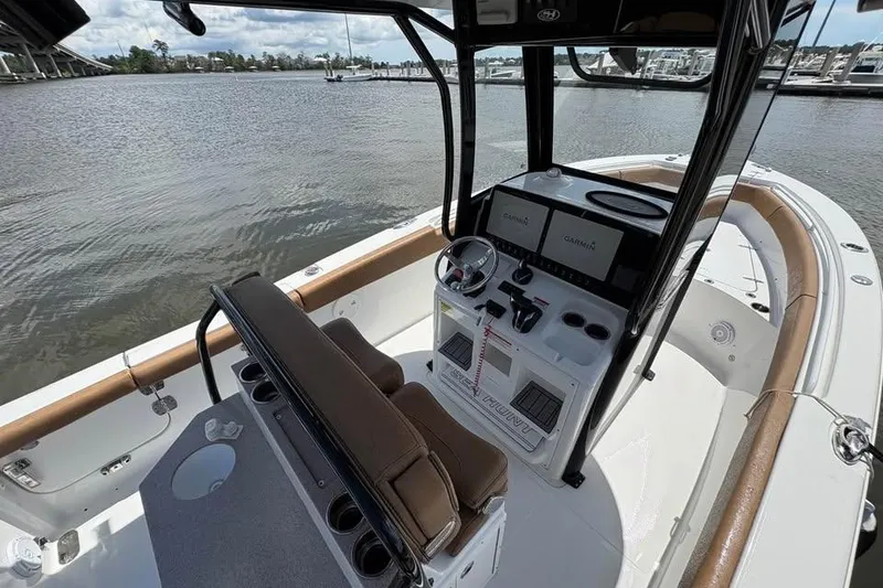 Slide: The Image of 2021 Seahunt 255 Ultra boat interior with helm, seating, and water view. - 11