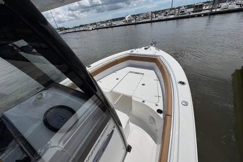 Slide: The Image of 2021 Seahunt 255 Ultra boat docked at marina, featuring spacious deck and sleek design. - 12