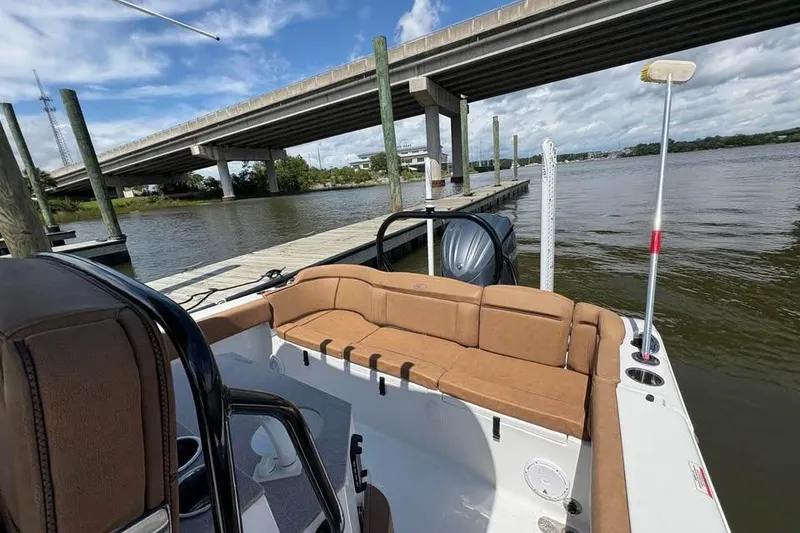 Slide: The Image of 2021 Seahunt 255 Ultra boat docked by a river under a bridge. - 13