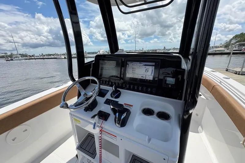 Slide: The Image of 2021 Seahunt 255 Ultra boat dashboard with steering wheel and navigation controls. - 15