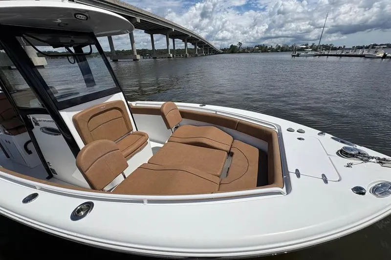 Slide: The Image of 2021 Seahunt 255 Ultra boat with tan seating, docked near a bridge on a cloudy day. - 18