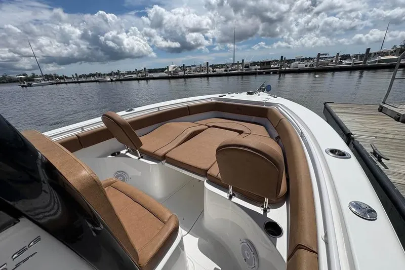 Slide: The Image of 2021 Seahunt 255 Ultra boat with tan seating at a marina dock. - 19
